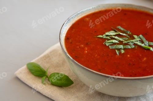 Preview: Homemade Tomato Basil Soup in a Bowl, low angle view. Close-up. Copy space.