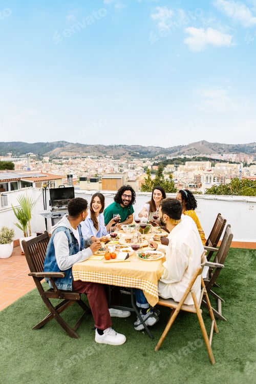 Preview: Vertical photo of a gathering of young friends having fun at barbecue dinner