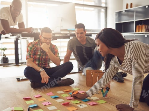 Preview: Group of workers sitting around notes on floor