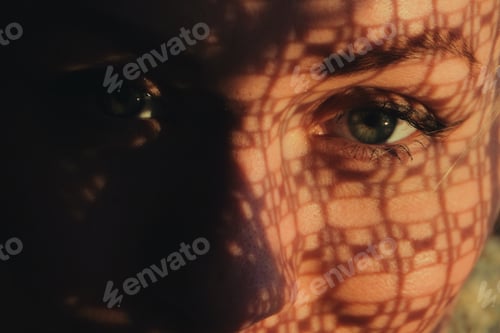 Preview: portrait of a woman standing next to a window, sunset through curtain cast a shadow on her face