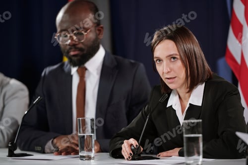 Preview: Young confident female politician in formalwear speaking in microphone