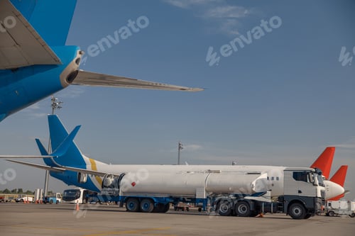 Preview: Airplane in airport refueling before flight with blue sky in the background