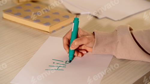 Preview: Cropped view of woman with marker writing on paper at home