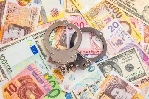 Preview: Handcuffs on various banknotes background. Top view.