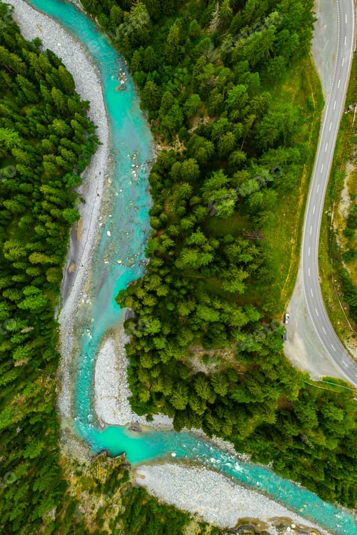 Preview: Inn River flowing in the forest in Switzerland. Aerial view from drone on a blue river in the