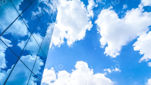 Preview: clouds reflected in the many mirrored facets of a modern office building