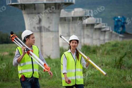 Preview: Civil engineers are taking measurements with surveying tools during the construction.