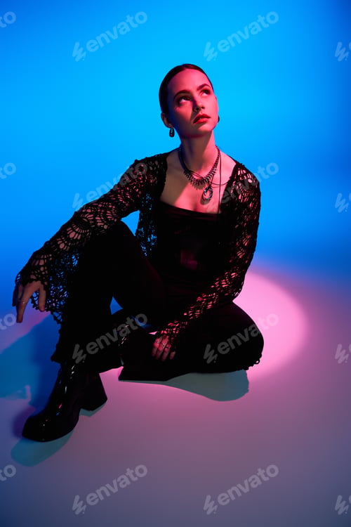 Preview: Stylish young woman poses elegantly in studio with bold colors and artistic flair