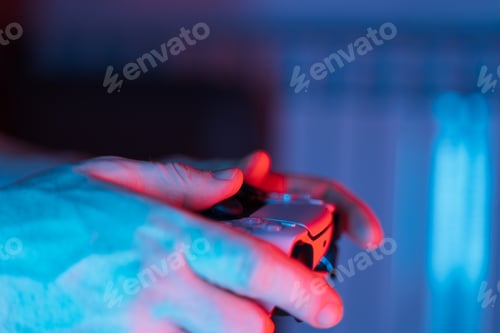 Preview: Man hands with game controller in neon light, top view