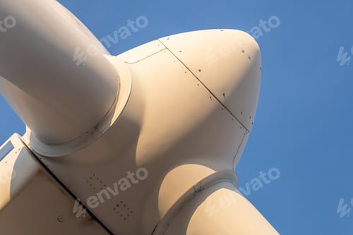 Preview: Low angle shot of the blades of a wind turbine under the clear blue sky