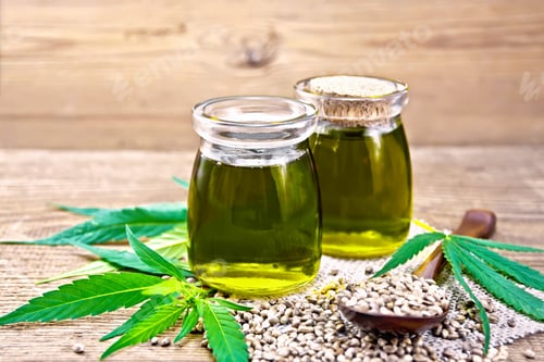 Preview: Oil hemp in two jars and spoon on board