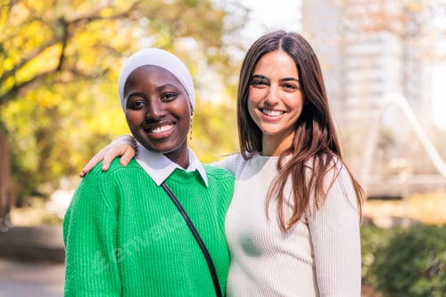 Preview: two young women smiling looking at camera
