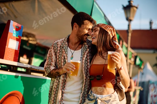 Preview: Affectionate couple enjoying in cold beer and summer music festival.