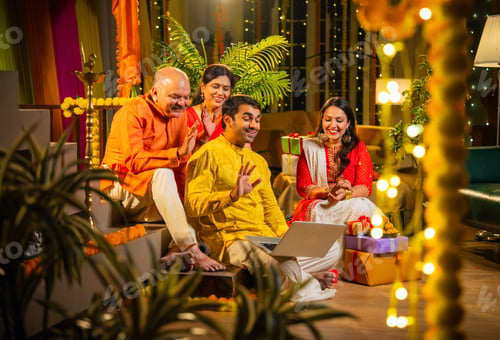 Preview: Celebrating Diwali with parents and children while joining video call at dining table with laptop