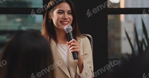 Preview: Confident young businesswoman or speaker sharing ideas with colleagues or audience