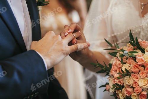 Preview: Beautiful bride and groom hands exchanging wedding rings in church