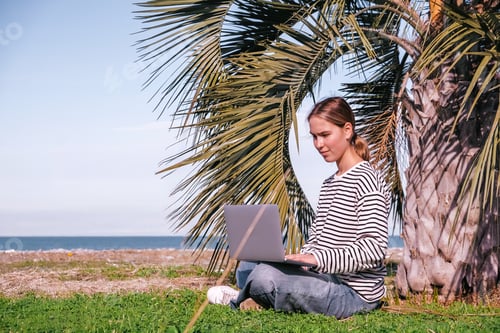 Preview: Remote work.Girl freelancer works remotely sea shore. workation, remote work,leisure, work life bala