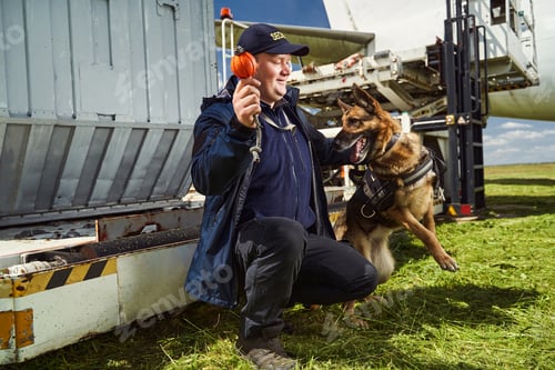 Preview: Security officer training detection dog in airfield