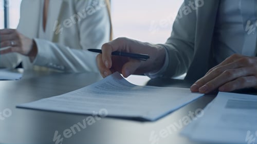 Preview: Closeup hands checking agreement in office. Business partners reading contract