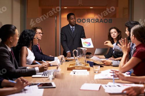 Preview: Black businessman stands to present to colleagues at meeting