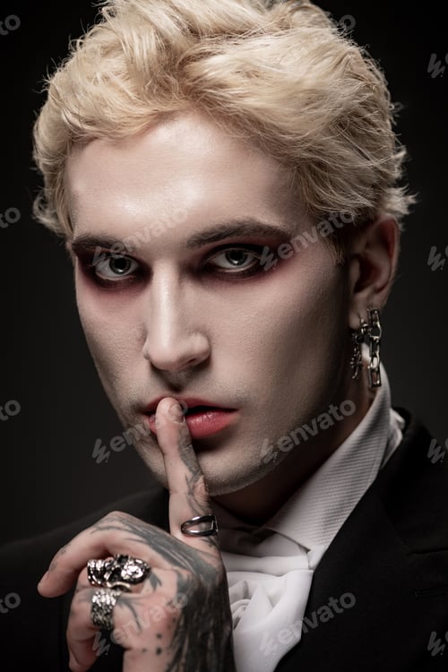 Preview: Young man showcases stunning Halloween costume with dramatic makeup in artistic setting