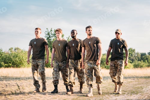 Preview: interracial soldiers in military uniform with tag dogs walking on range on summer day