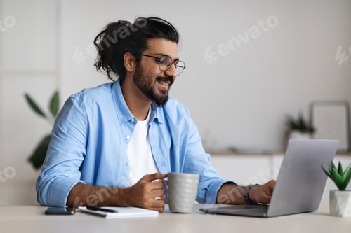 Preview: Pros of Freelancing. Positive Freelancer Guy Drinking Coffee And Working On Laptop