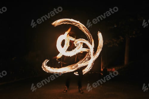 Preview: Fire dancers swing, spinning fire and man juggling with bright sparks in the night