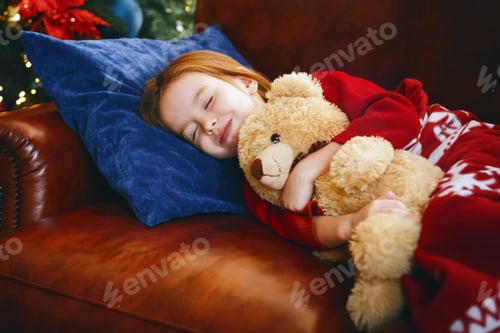 Preview: Little girl sleeping near illuminated xmas tree