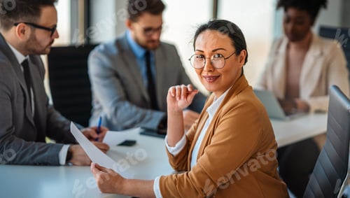 Preview: Multicultural professional businesspeople working together on research plan in boardroom.