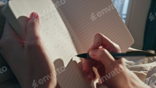 Preview: Female hands writing diary in sunlight closeup. Woman making notes in morning