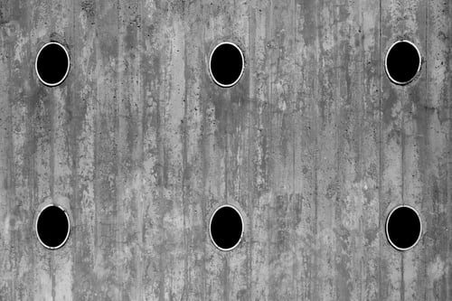Preview: Brutal concrete industrial wall with black pipes inside.