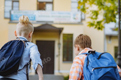 Preview: children running to school with backpacks on sunny day. Begining of academic year. Boys by school