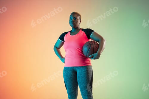 Preview: Young african-american plus size female model's training on gradient background