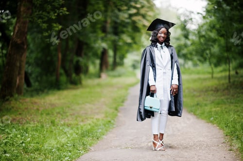 Preview: Graduate Posing with Cap and Gown in Park