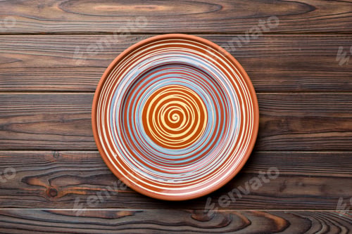 Preview: Top view of empty colorful plate on wooden background. Empty space for your design