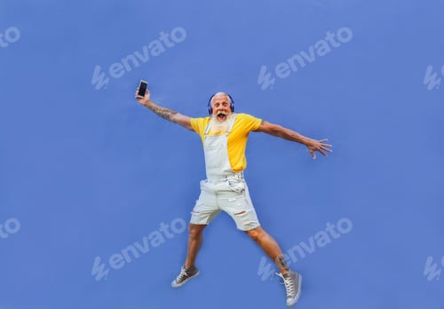 Preview: Cheerful hipster man jumping - Happy senior enjoy technology