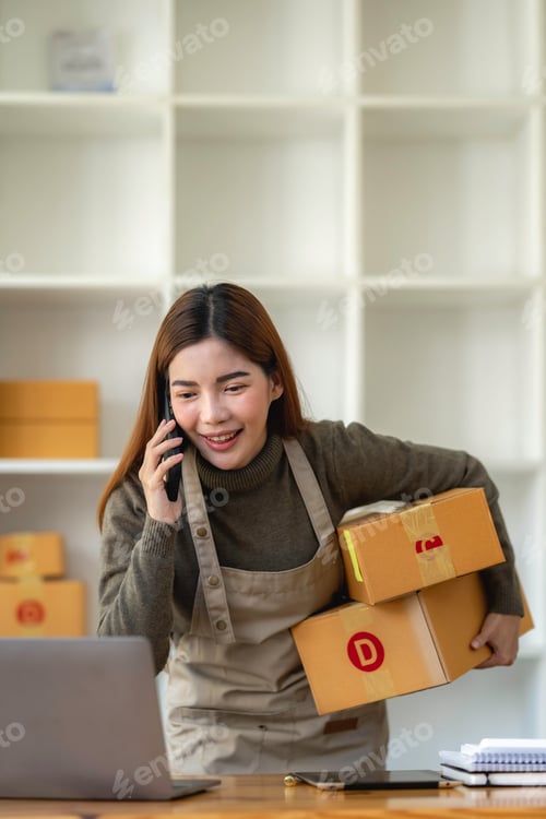 Preview: Asian Small business entrepreneur SME working with box and On the phone to confirm orders with custo