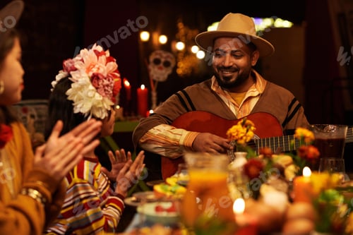Preview: Man playing guitar at dinner party