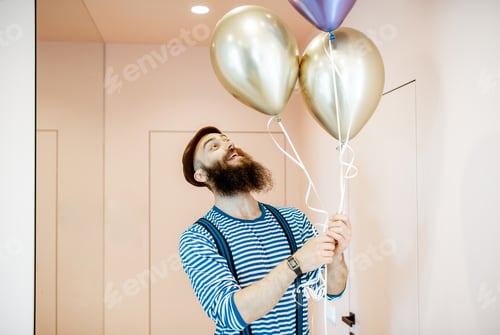 Preview: Festive man with balloons indoors
