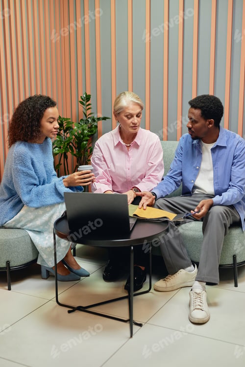 Preview: Senior Businesswoman Discussing with Team Interior Design while Sitting on Couch in Coworking