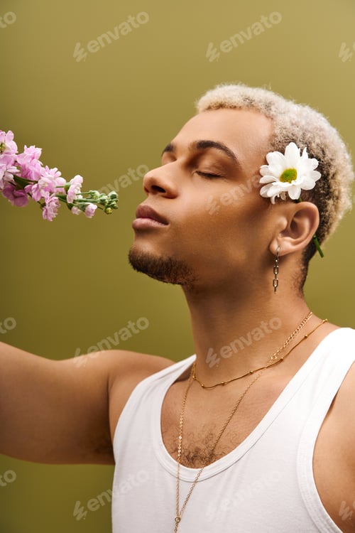 Preview: Young man with dyed hair embraces nature in a trendy studio setting with flowers