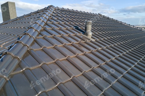 Preview: Closeup of ventilation pipe on house roof top covered with ceramic shingles.