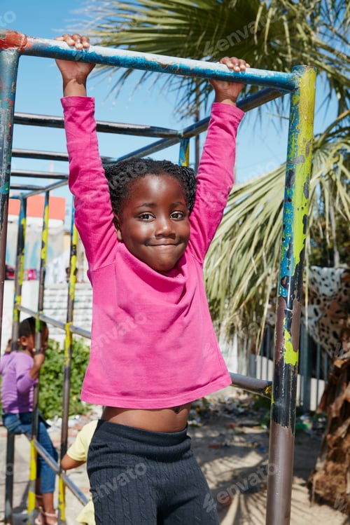 Preview: Portrait of a happy little girl hanging on a jungle gym