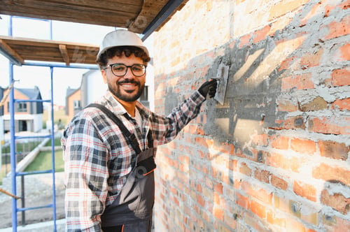 Preview: Construction worker plastering brick wall with trowel