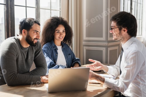 Vista previa: Feliz, joven y diverso marido y mujer, asesor legal consultor, agente inmobiliario, hablando sentados en la mesa.