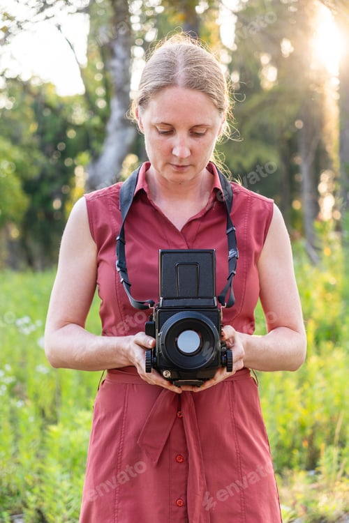 Preview: Young woman takes pictures in nature