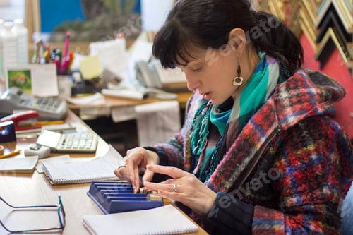 Preview: A woman counting coins in a shop, close up hands and coins