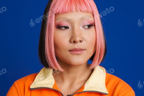 Preview: Asian girl with pink hair and piercing posing while looking aside