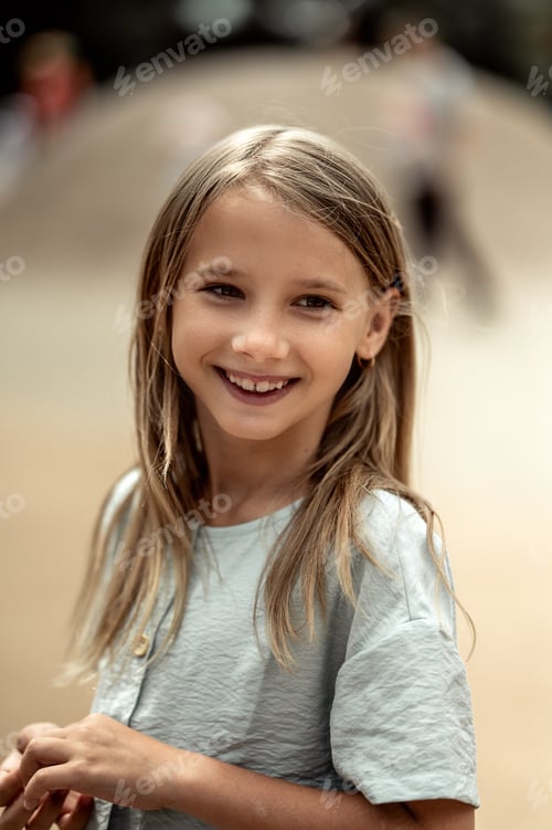 Visualização: retrato de uma linda garota de 6-7 anos com longos cabelos loiros. Uma garota caminha no parque
